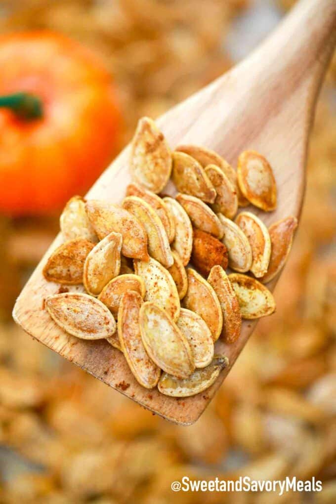 roasted pumpkin seeds on a wooden spoon