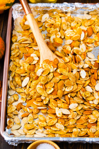 Homemade roasted pumpkin seeds on a baking sheet.