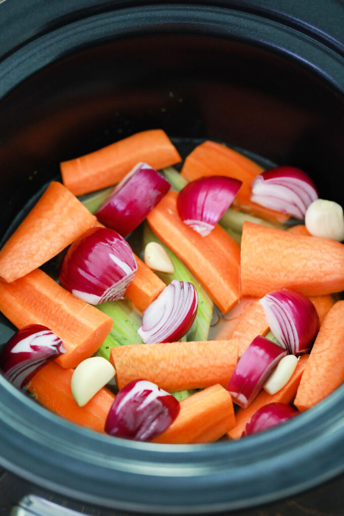 Carrot chunks, celery, and onion in the slow cooker.