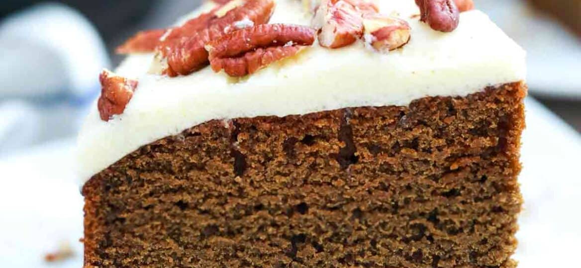 sliced instant pot gingerbread cake with frosting and pecans