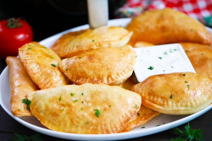 Crispy air fryer beef empanadas with a dipping sauce.