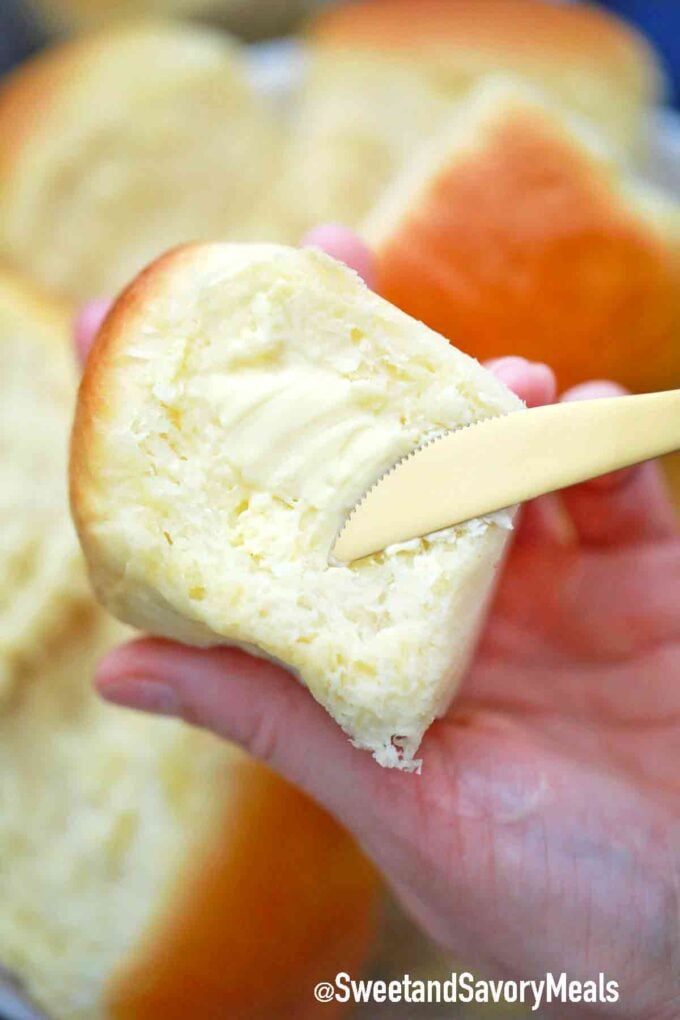 spreading butter on a dinner roll