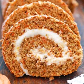 sliced carrot cake roll on a wooden cutting board