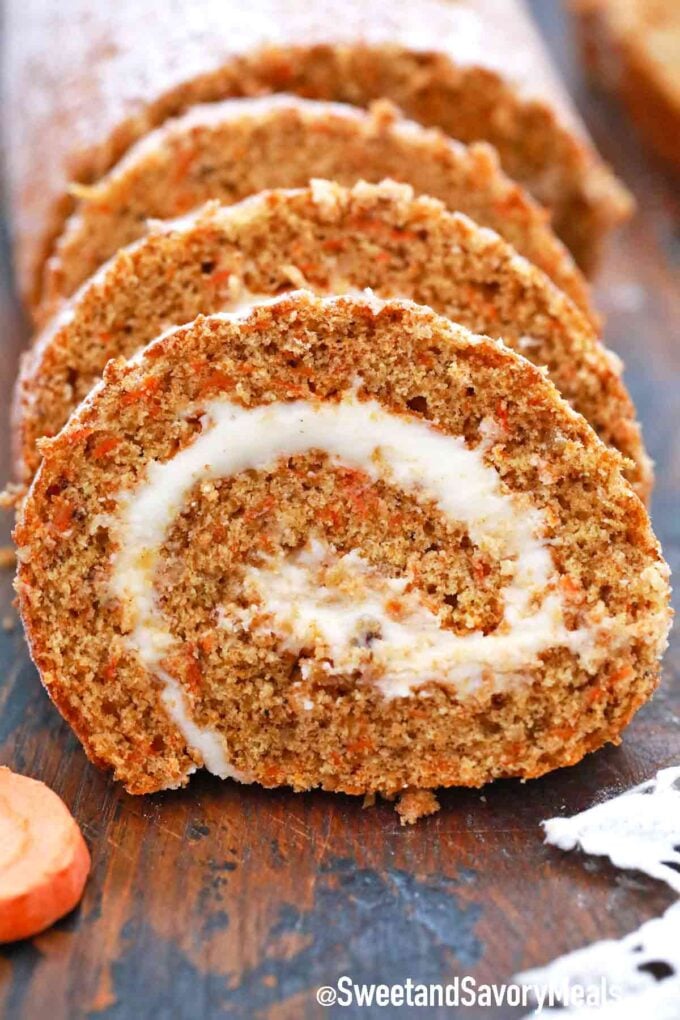 sliced carrot cake roll on a wooden cutting board