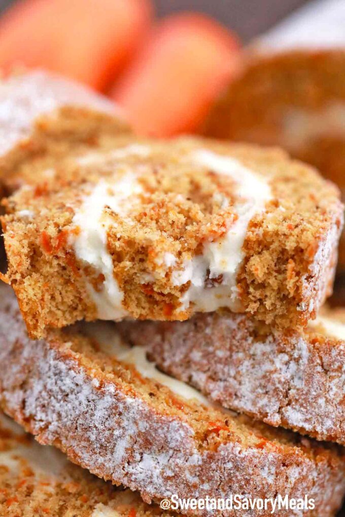 a carrot cake roll slice cut in half on top of other slices