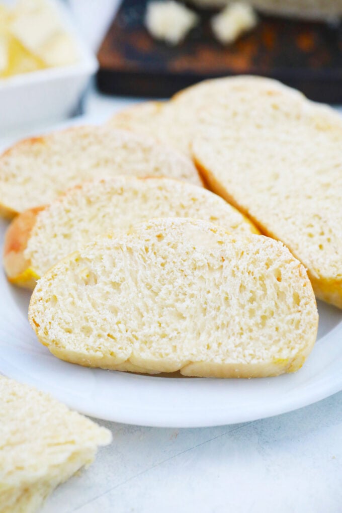 Slices of fluffy homemade challah bread on a plate.