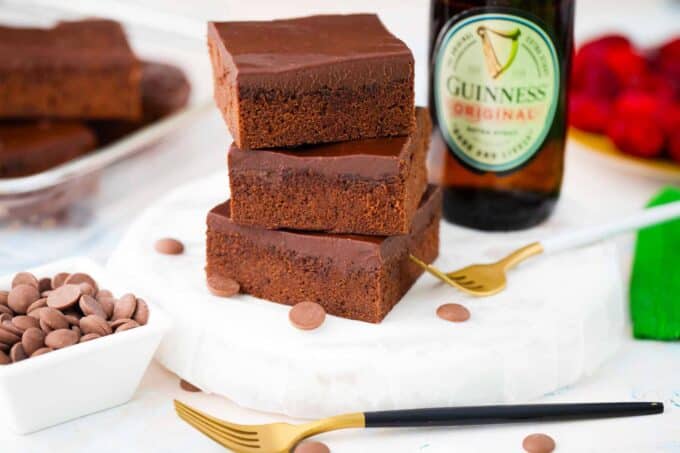 three guinness chocolate brownies stacked on top of each other next to a guinness beer