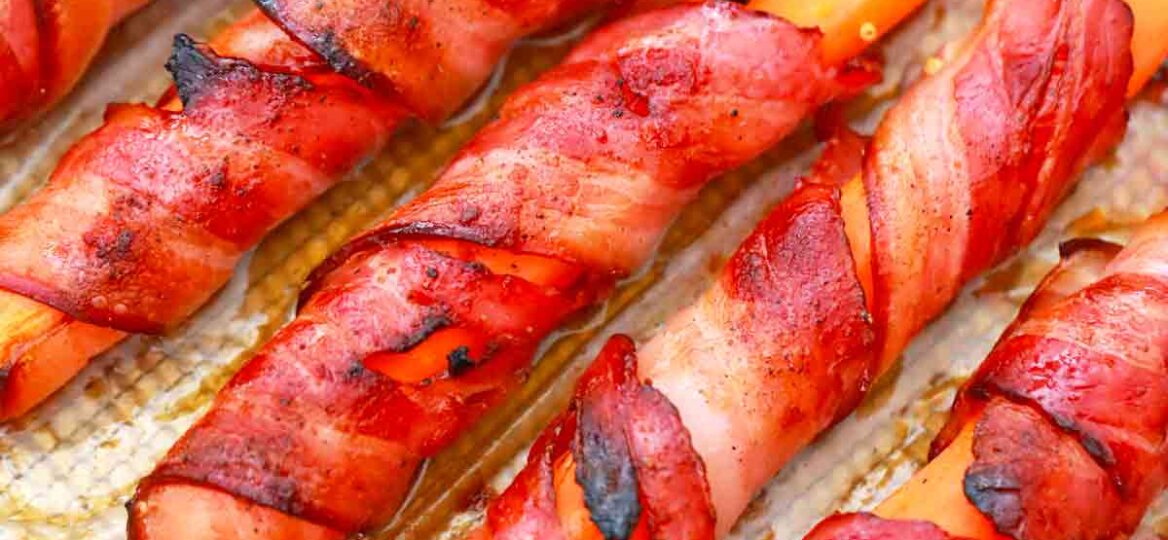 a baking sheet of bacon wrapped carrots