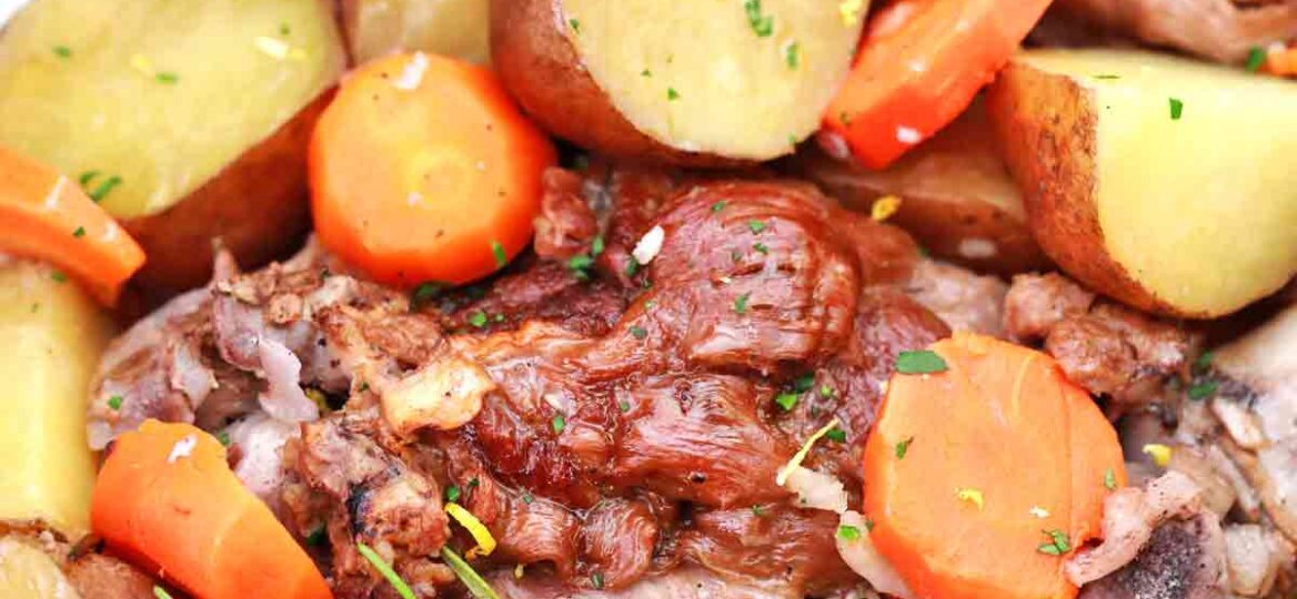 plate with leg of lamb, potatoes and carrots