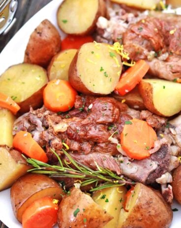 plate with leg of lamb, potatoes and carrots