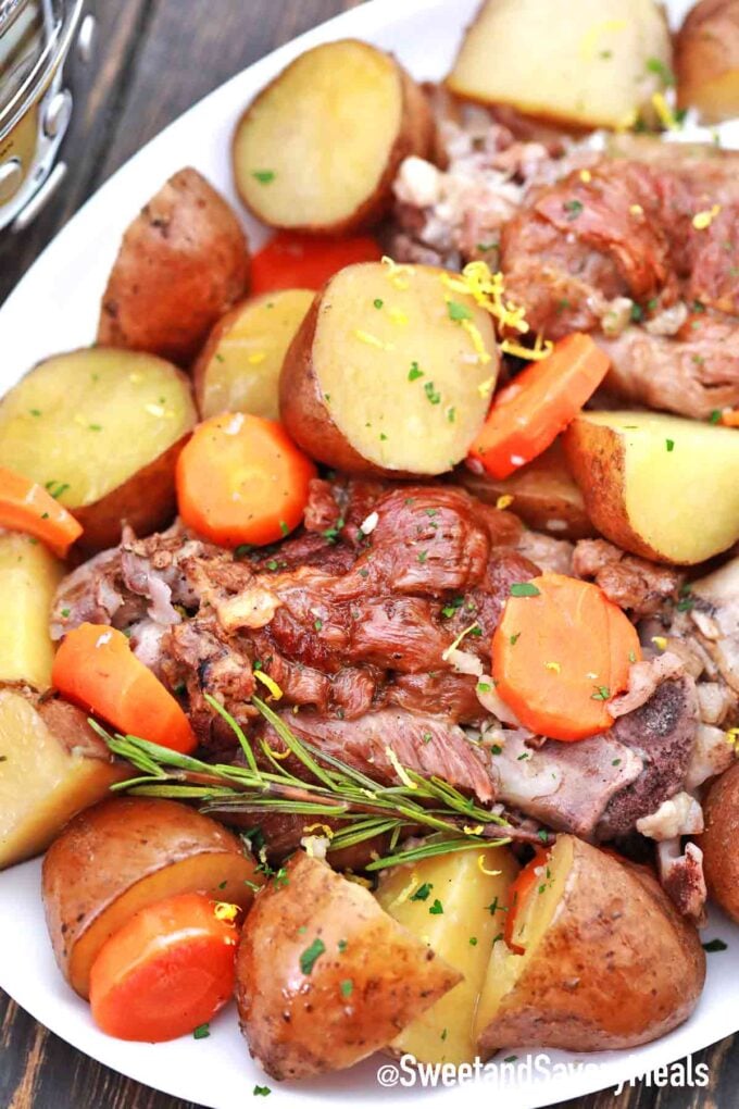 plate with leg of lamb, potatoes and carrots