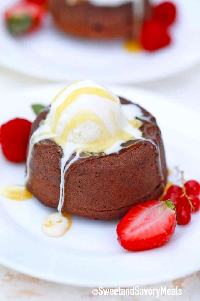 chocolate lava cake topped with ice cream and served with strawberries on the side