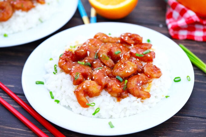 A plate of white rice topped with crispy orange shrimp.