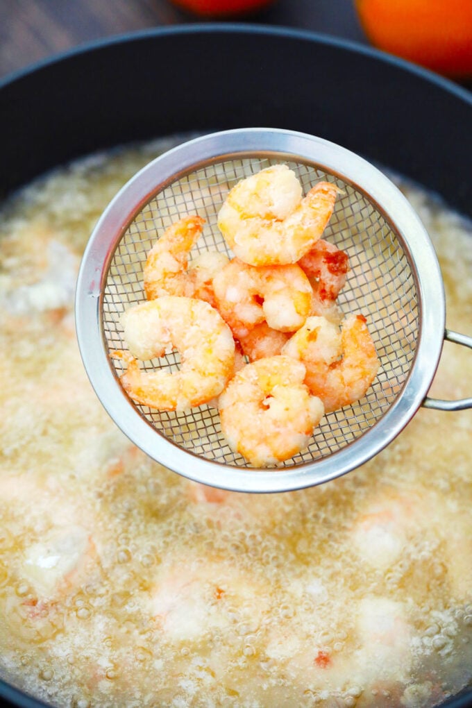 Frying shrimp in a pan with oil.