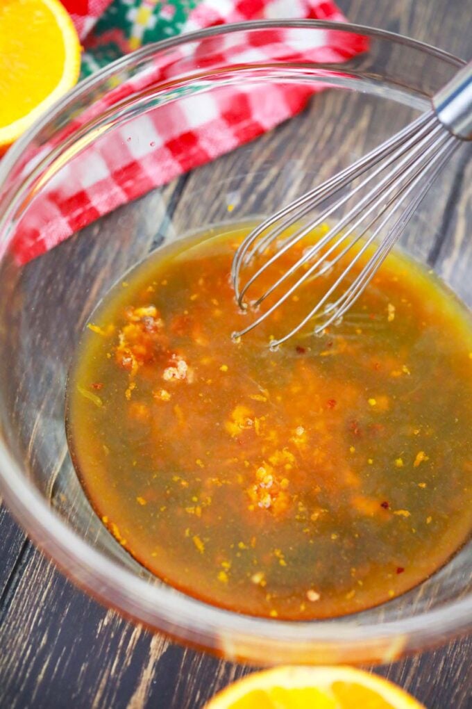 Whisking homemade orange sauce in a bowl.