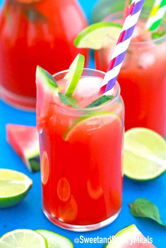 a glass of watermelon lemonade with lime slices