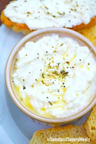 a bowl of homemade ricotta topped with olive oil and ground black pepper