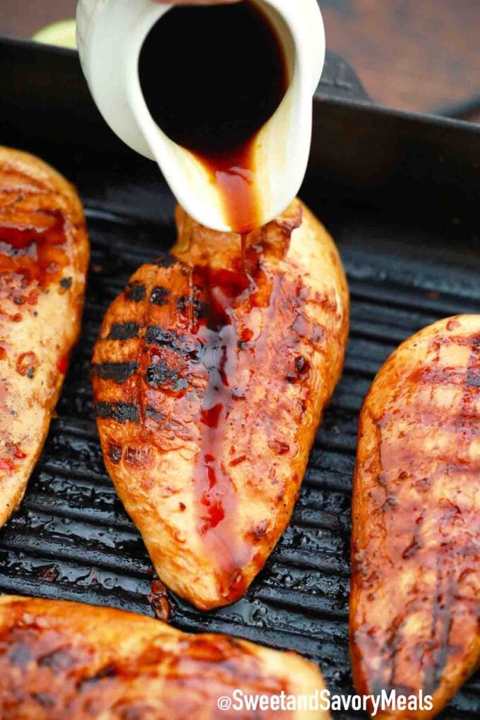 pouring sauce over grilled chili lime chicken in a cast iron grill pan