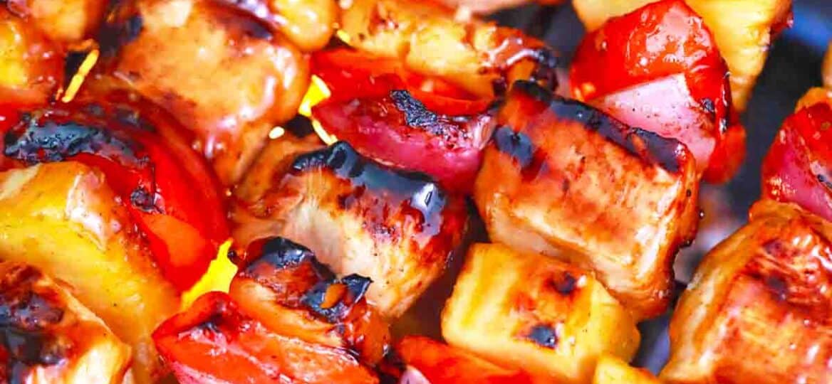 BBQ chicken kabobs cooking on an outdoor grill