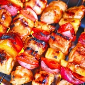 BBQ chicken kabobs cooking on an outdoor grill