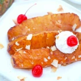 fried pineapple served with whipped cream and maraschino cherries topped with toasted coconut