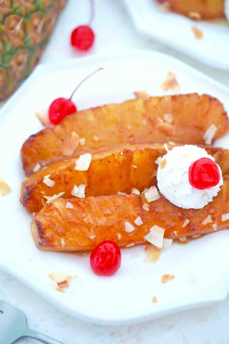 fried pineapple served with whipped cream and maraschino cherries topped with toasted coconut