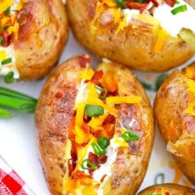 grilled baked potatoes with toppings on a serving plate