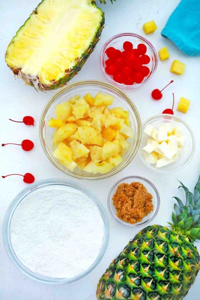 pineapple maraschino cherries and other ingredients in bowls arranged on a table
