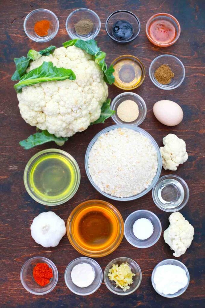 cauliflower and ingredients in bowls on a wooden table