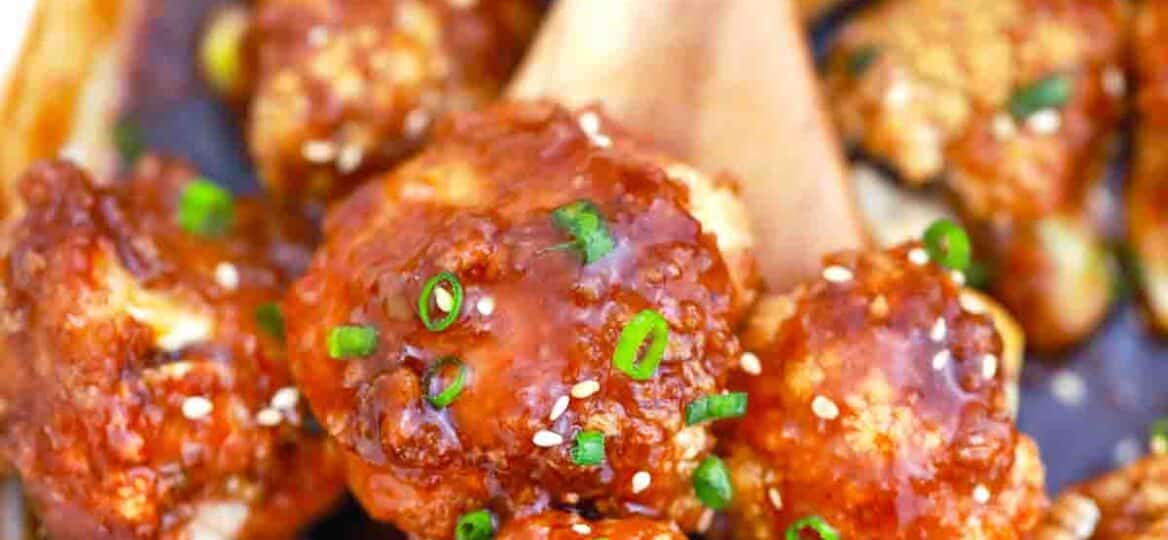 close shot of a spoonful of sticky sesame cauliflower in a sauce