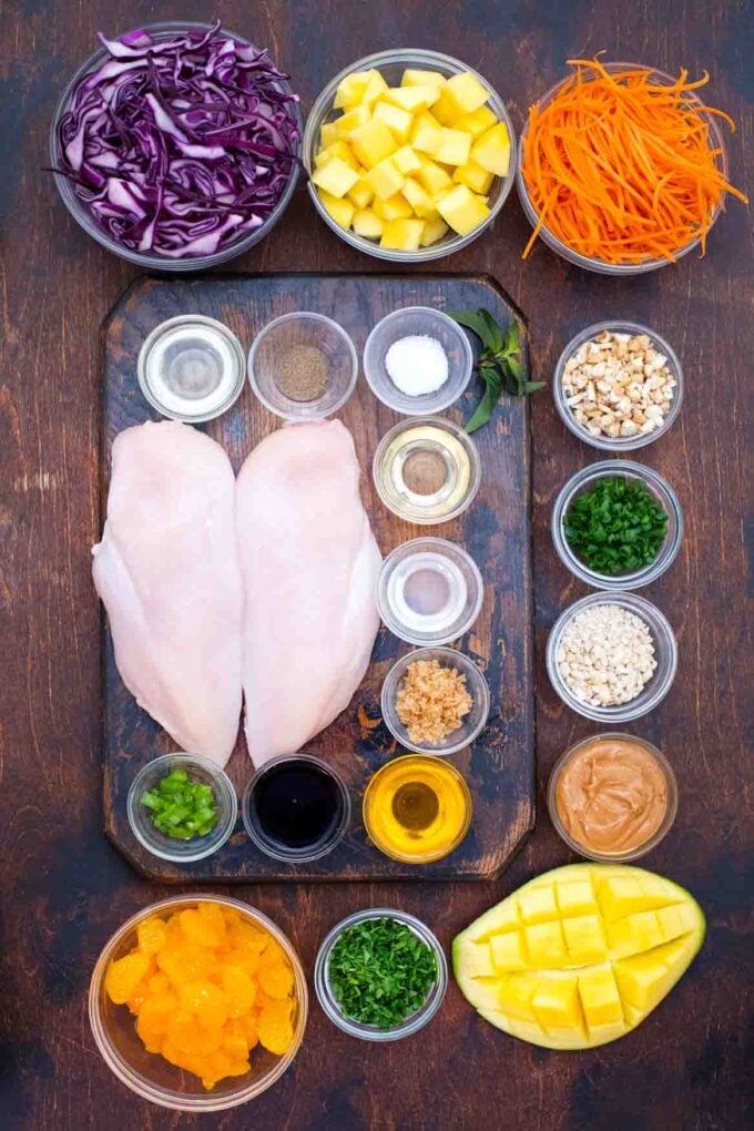 overhead shot of ingredients for Chinese chicken salad arranged in bowls on a table