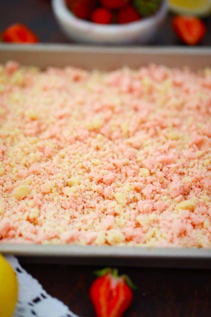 Strawberry vanilla crumbs on a baking sheet.