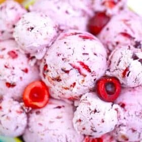 a bowl of homemade cherry ice cream with fresh cherries