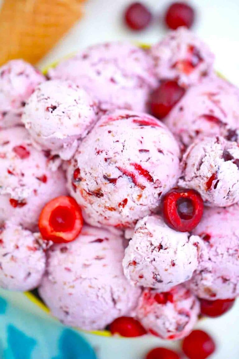 a bowl of homemade cherry ice cream with fresh cherries