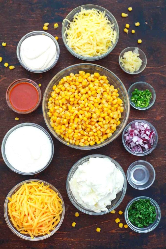 overhead shot of corn cheese onion sour cream mayo garlic hot sauce in bowls on a table