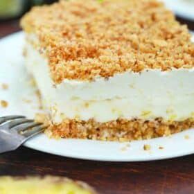 a slice of no bake pineapple dream dessert with a pineapple in the background