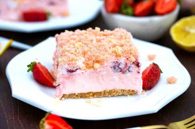 a slice of strawberry dream dessert topped with strawberry crumbles