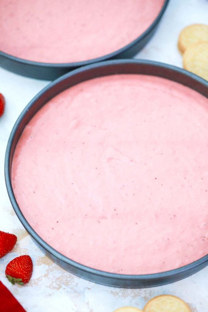 Strawberry cake batter in baking pans.