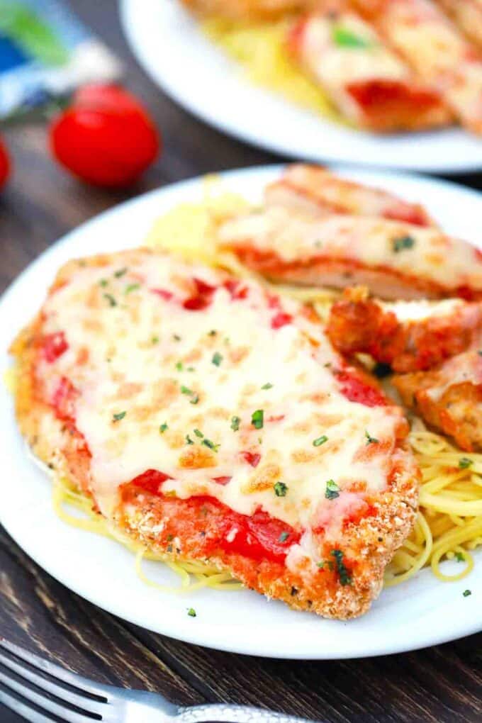air fried chicken parmesan covered in cheese served with spaghetti