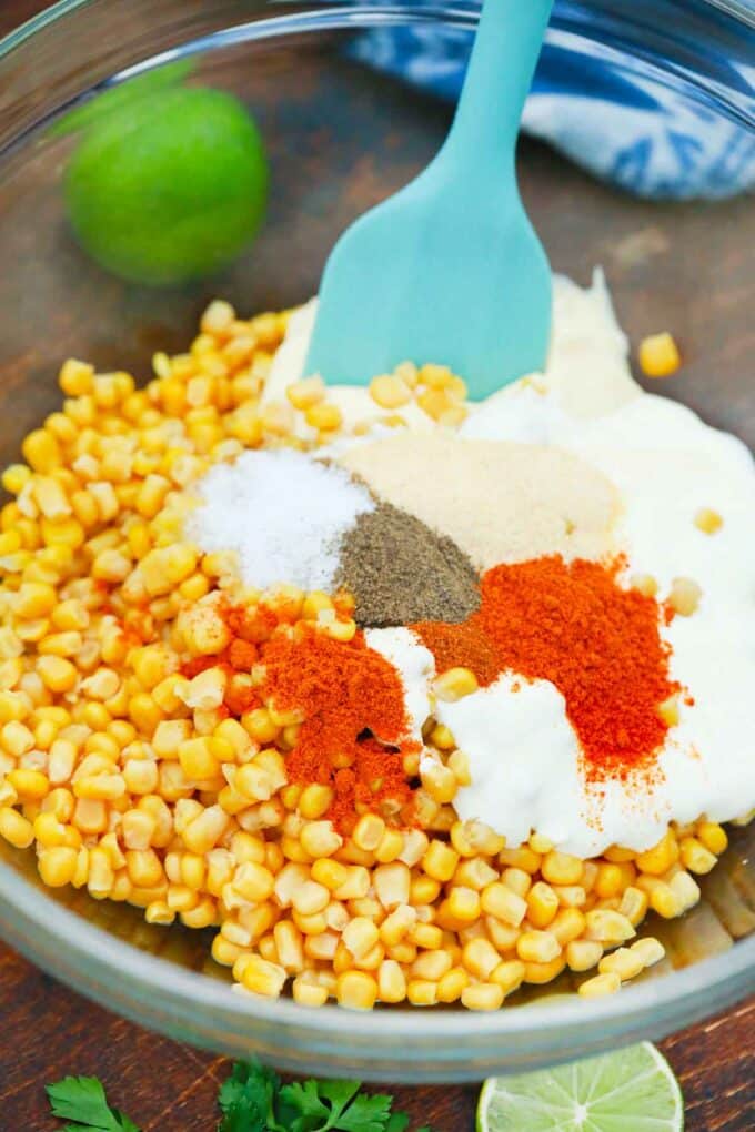 Mixing corn, spices, and mayo in a bowl.