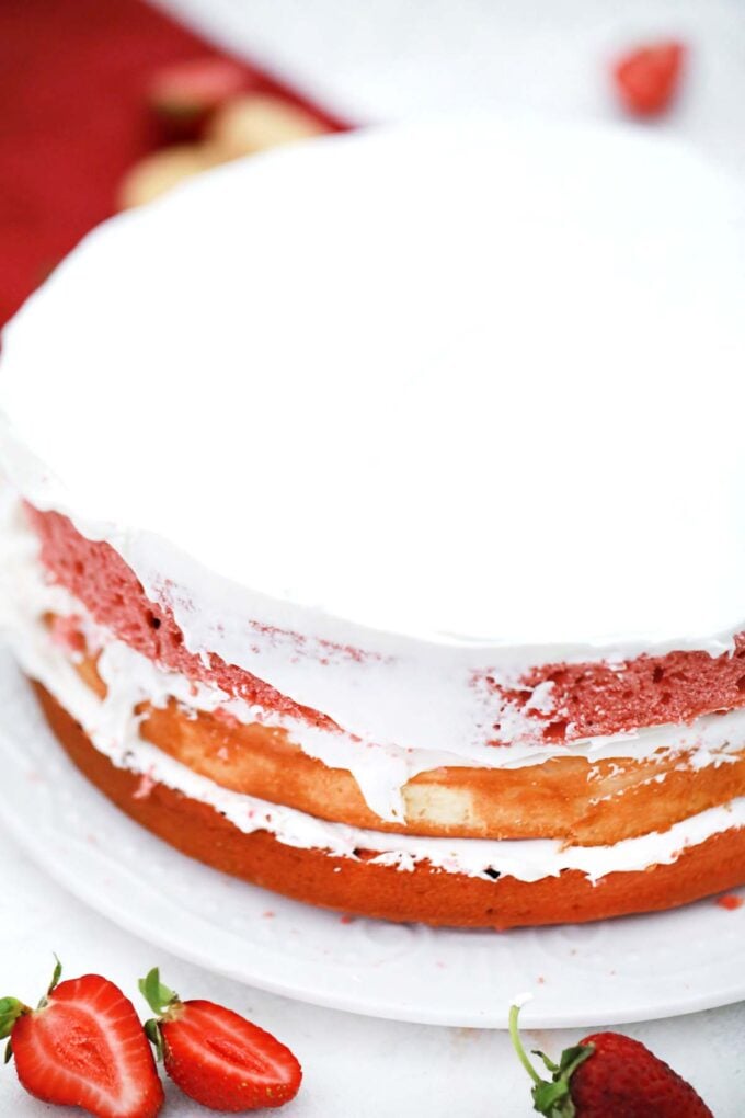 Layering the strawberry crunch cheesecake cake.