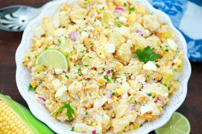 bowl of mexican street corn potato salad garnished with lime