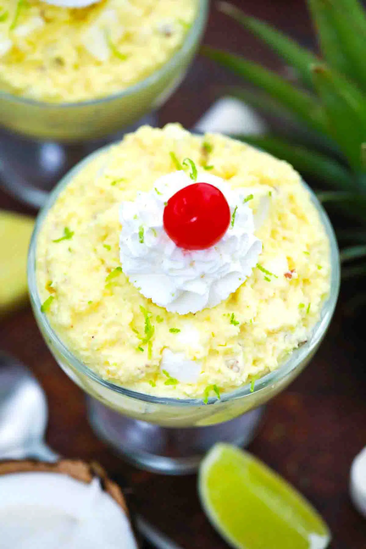 overhead shot of pineapple fluff topped with whipped cream and maraschino cherry