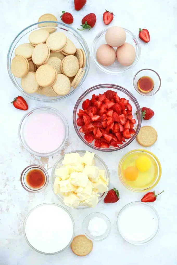 overhead shot of golden Oreo cookies strawberries eggs sugar flour in bowls on a table