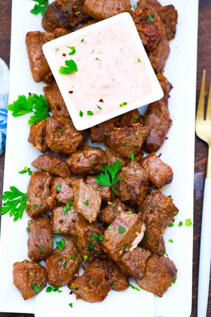 overhead shot of a plate of air fried steak bites with dipping sauce