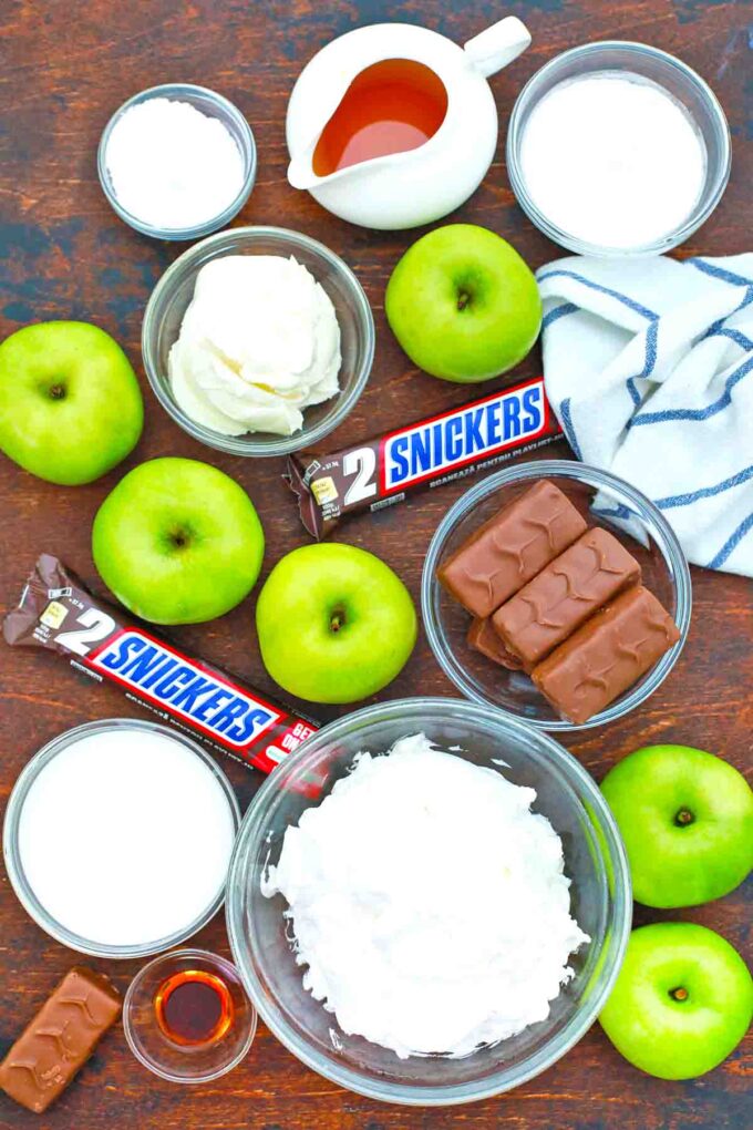 overhead shot of snickers bars whipped topping apples caramel pudding on a table
