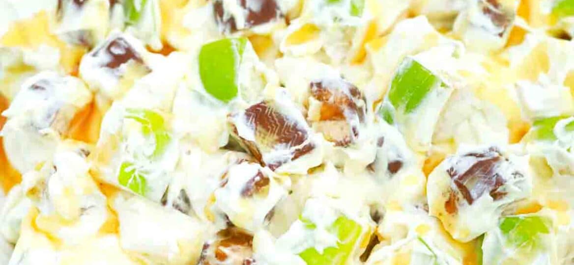 overhead shot of a bowl of apple snickers salad with a snickers bar in the background