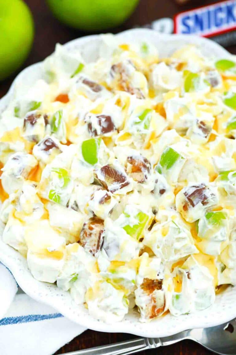 overhead shot of a bowl of apple snickers salad with a snickers bar in the background