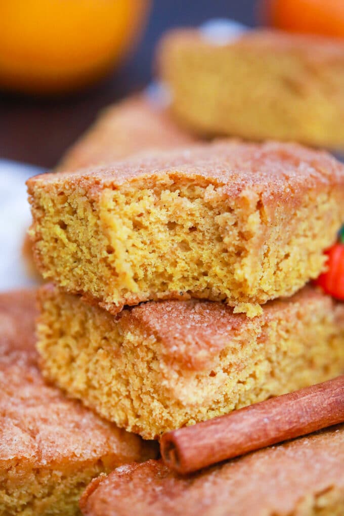 stack of pumpkin snickerdoodle bars with a bite taken of the top one