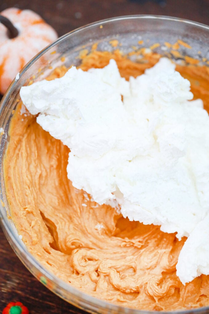 Folding whipped cream into pumpkin mousse.